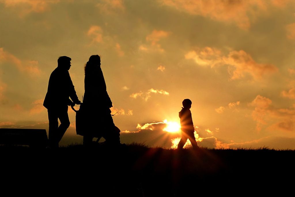 Divorced couple walks peacefully with their kids.