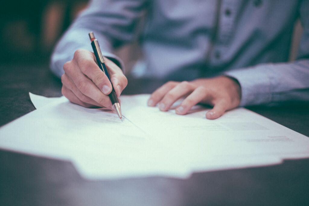 Person reviewing and signing alimony documents after reaching an agreement.