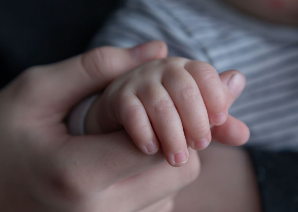 Parent holding the hand of their child after reaching an agreement on child support.