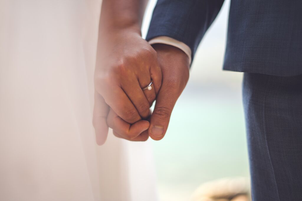 A close up of two people holding hands after obtaining a fiancé visa.